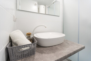 Detail of counter top washbasin in modern bathroom with accessories of steel and vase