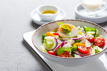 Healthy mixed salad with arugula, egg, onion, feta cheese and radish