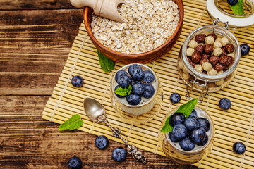 Healthy and useful breakfast concept. Yogurt with blueberries, oat-flakes and chia seeds