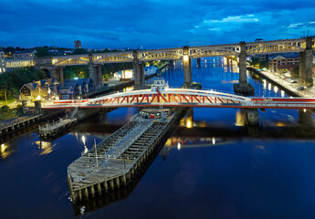 Elevated view of the 'Bridge Street' swing bridge at the Newcastle upon Tyne quayside illuminated...