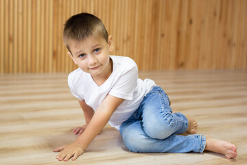 Naklejka premium Cute little boy in white t-shirt posing. Portrait of a fashionable male child. Smiling boy posing. The concept of children's style and fashion. 