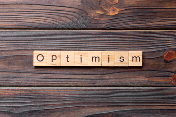 Optimism word written on wood block. Optimism text on cement table for your desing, concept