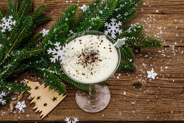 Traditional prune dessert with nuts and whipped sour cream with sugar. New Year's sweet treat concept. Wooden boards background