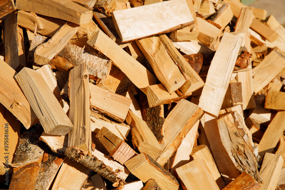 Poster chopped firewood lie in a heap. horizontal cropping