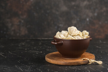 Traditional Russian and Ukrainian dish dumplings in a clay bowl on a wooden Board