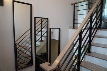 Staircase and mirror hang on the wall in a house