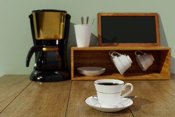 Black coffee in a white ceramic mug with gold rim and saucer. Blur Black and gold espresso machine and Coffee cup storage on  Wooden table and mountain view. 3D Rendering
