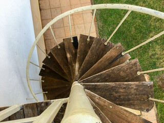 A flight of spiral stairs with metal and old wood