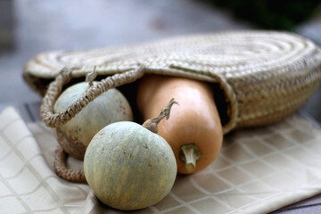 Various pumpkins in a wicker bag. Selective focus.