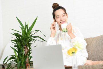 ソファーの上で電話をする若い女性