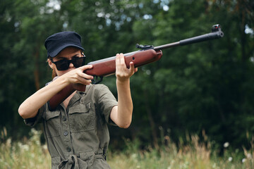 Woman soldier Sunglasses weapon aiming hunting green leaves 