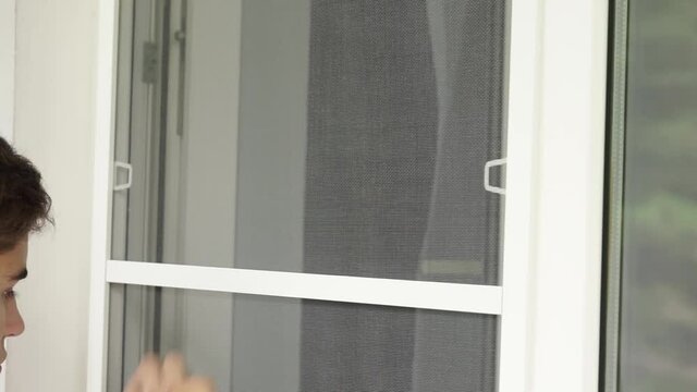 A man cleans a mosquito net from flies and mosquitoes