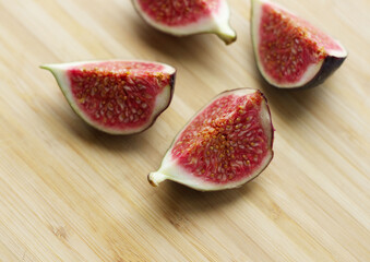 Spread the halves of the figs on a wooden surface. Delicious breakfast with figs, delicacies, proper nutrition, good morning, snacks, juicy fruit halves. The benefits and harms of figs