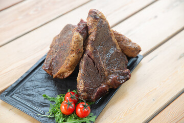 large steak from  grilled t-bone decorated with herbs  tomatoes and salt
