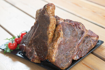 large steak from  grilled t-bone decorated with herbs  tomatoes and salt