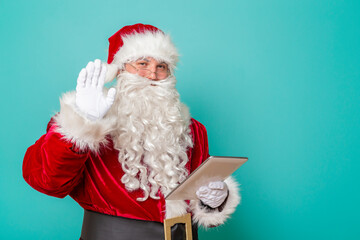 Santa Claus waving and using tablet computer