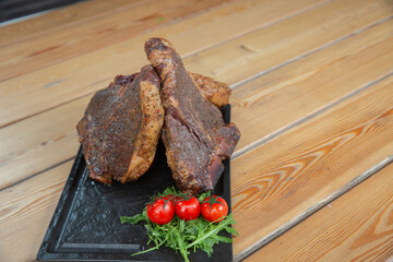 large steak from  grilled t-bone decorated with herbs  tomatoes and salt