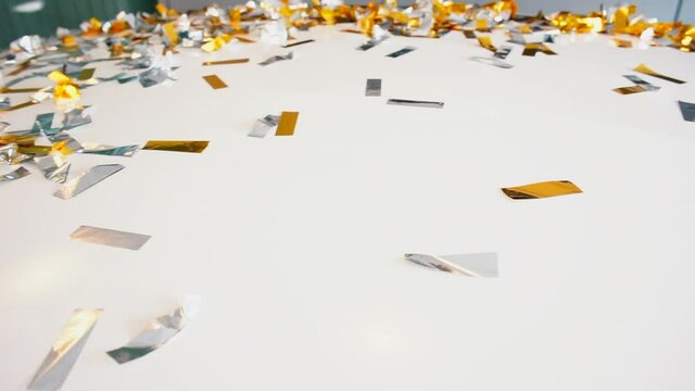 Festive confetti scatters on a white surface. An attribute of the holidays during the celebration of a wedding party.