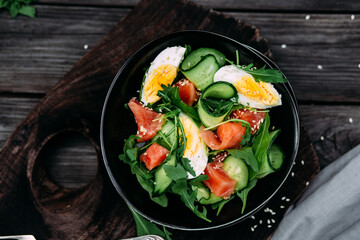 Salad with salmon, arugula, cucumber and egg