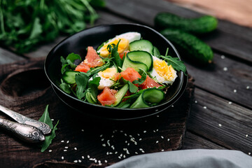Salad with salmon, arugula, cucumber and egg