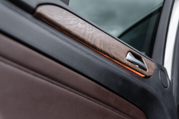 Interior light under the door open handle, wooden and braun leather door panel
