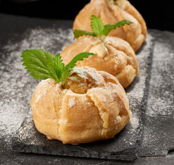 baked custard eclairs and sprinkled with powdered sugar and decorated with a mint leaf
