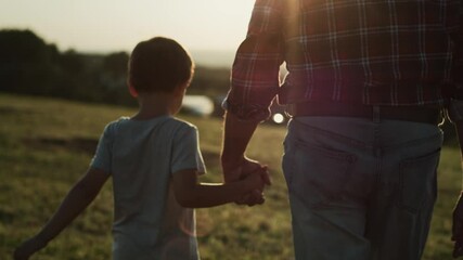 Rear view video of grandfather and grandson walking at sunset. Shot with RED helium camera in 8K.