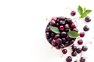 Layout of sweet cherries with leaves, top view, copy space