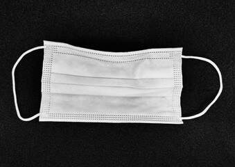 White medical mask on a black background.