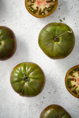 Colored tomatoes on a gray concrete background.