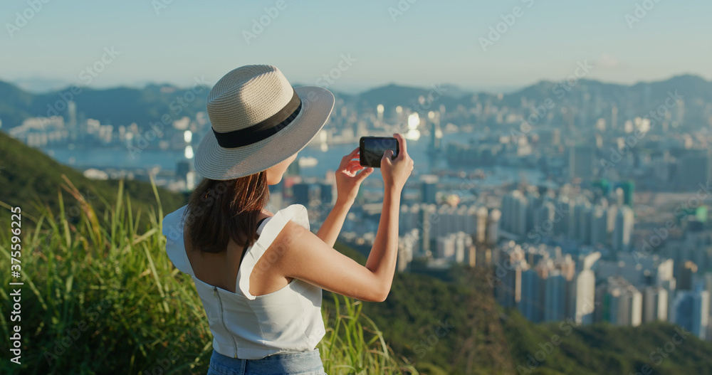 Canvas Prints Woman use of cellphone to take photo under sunset