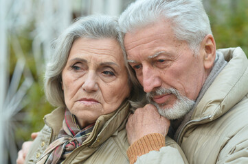 Portrait of sad thoughtful senior couple in park