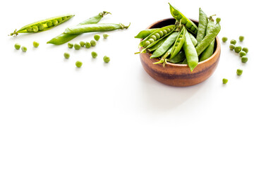 Bowl of green pea pod with beans on kitchen desk. Close up