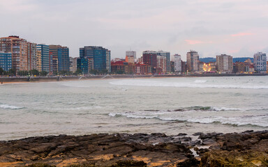 Paseo y Playa de San Lorenzo con edificios mirando al mar al atardecer . Gijon. Asturias. España 