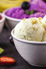 banana ice cream in recycled plastic pot, with fruits around