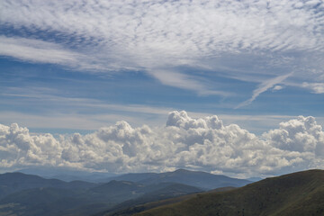 Cloudy sky over blue mountains.