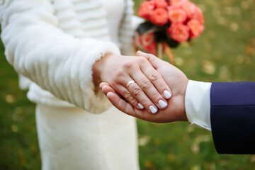 Hands of newlyweds with wedding rings and a wedding bouquetf. newlyweds with wedding rings and a wedding bouquet