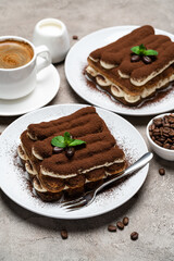 Classic tiramisu dessert, cup of coffee, sugar and milk on concrete background