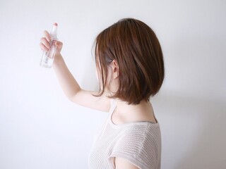 化粧水をスプレーする女性