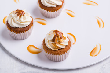 cream cupcake on white plate, top view, close-up