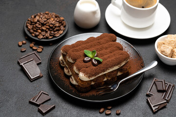 Classic tiramisu dessert, cup of coffee, sugar and milk on concrete background