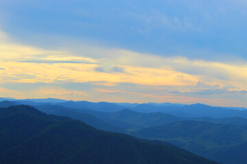 Fototapeta na wymiar Sunset, dawn in the mountain range, blue fog.