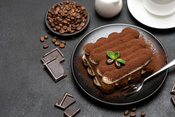 Classic tiramisu dessert, cup of coffee, sugar and milk on concrete background