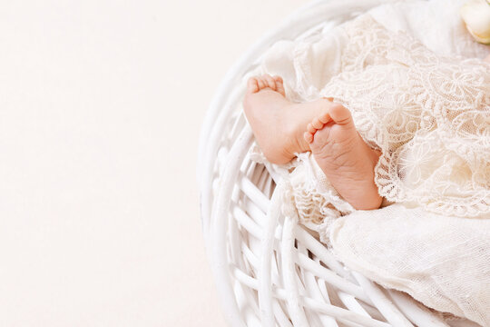 Newborn baby feet on openwork plaid. Closeup picture. Tiny newborn baby's feet  closeup. Copy space
