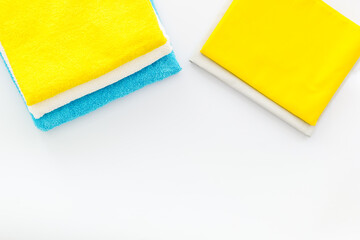 Stack of bath towels and clothes on ironing board