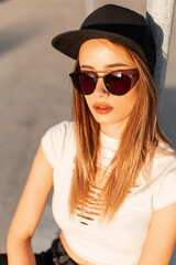 Portrait fashion young girl hipster with sexy lips in white torn top in fashionable sunglasses in...