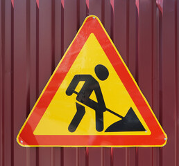 new modern Roadworks Sign on a Busy Road. iron fence. Road sign pedestrian zone and pedestrian...