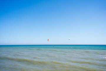 Fototapeta premium Kite surfing on blue sky ocean waves outdoors background.
