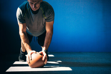 Close up of fitness man doing push ups on a medicine ball.