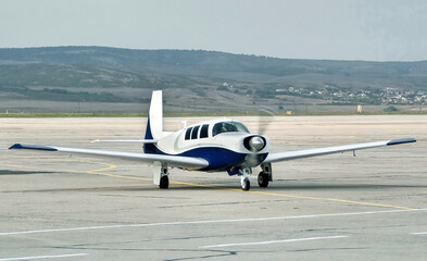 Side view of piston powered airplane, propeller driven aircraft, with low wings and tricycle gear. Modern technology in fast transportation, business travel and tourism, aviation.